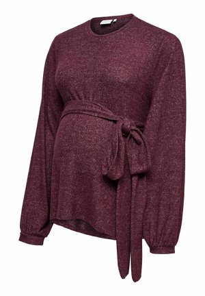 Bordo majica za trudnice s dugim rukavima, okruglim izrezom i detaljem vezanja u struku. Izrađena od mekane, teksturirane tkanine za udobnost.