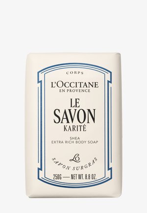 Barra di sapone corpo extra ricca al burro di karité L’Occitane, 250 g, etichettata "Le Savon Karité" con bordo decorativo blu navy su confezione color crema.