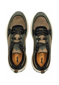 Zapatillas en verde oliva y tan con acentos negros, materiales de ante y malla, suela blanca gruesa y logo en la lengua y el talón.