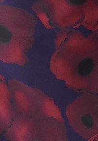 Květinová látka s velkými červenými makovými květy na tmavě fialovém pozadí. Jemná textura, s černými středy a rozmazanými okraji.