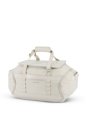 Bolsa de deporte de color crema hecha de tela duradera, con una parte superior con cremallera, asas resistentes y correas ajustables de textura suave.