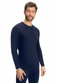 Marineblauwe thermoshirt met lange mouwen, een getailleerd ontwerp, geribbelde schouderaccenten en een ronde hals. Zacht, rekbaar materiaal voor comfort.