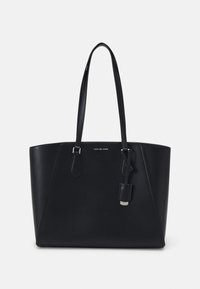 Sac fourre-tout en cuir noir avec deux longues poignées, quincaillerie en argent et une petite étiquette en cuir attachée, portant le logo de Michael Kors.