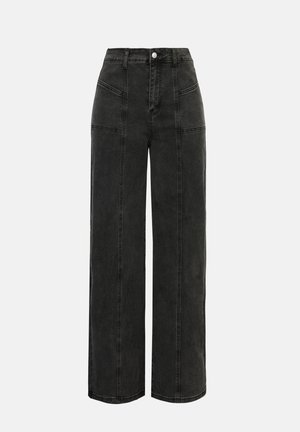 Μαύροι τζιν παντελόνες με φαρδιά γραμμή, ψηλή μέση, εμπρόσθιες τσέπες και έντονη ραφή σε αντίθεση. Διαθέτουν κλείσιμο με ένα κουμπί και ελάχιστες λεπτομέρειες.