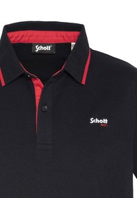 Svart polo-skjorte med ensfarget design, røde kragekanter, og brodert "Schott NYC"-logo. Har to knappeåpninger og teksturert stoff.