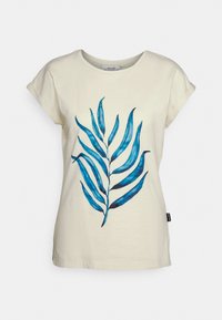 T-shirt de algodão creme com mangas curtas, apresentando um design de folhas azuis. A arte inclui diferentes tonalidades de azul com linhas detalhadas.