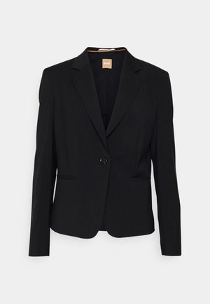 Čierny blazer z hladkého materiálu, s jedným gombíkom na zapínanie, klopovými goliermi a dvoma prednými vreckami. Strih na mieru s dlhými rukávmi.