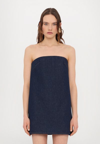 Robe en denim sans manches de couleur bleu foncé, avec une coupe droite et des détails minimalistes, présentant des bords nets et des accents de couture subtils.