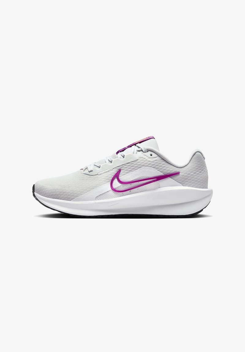 Chaussure de course Nike en maille gris clair avec des accents violets, présentant une silhouette élancée, un système de laçage et des détails texturés sur le talon.