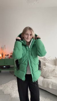 Roheline sulejope kapuutsiga, millel on mustad aktsendid, tõmblukk- ja nööpklambritega sulgur ning mitmed taskud. Disain on üle suuruse ja tikandiline.