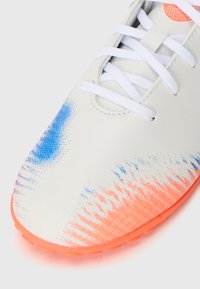 Vita fotbollssko med en gradientdesign i blått och orange, strukturerad yta och vita snören.