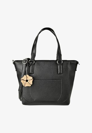 Zwarte handtas van getextureerd leer met dubbele handvatten, voorvak, verstelbare schouderband en een beige bloemvormige hanger bevestigd aan de band.