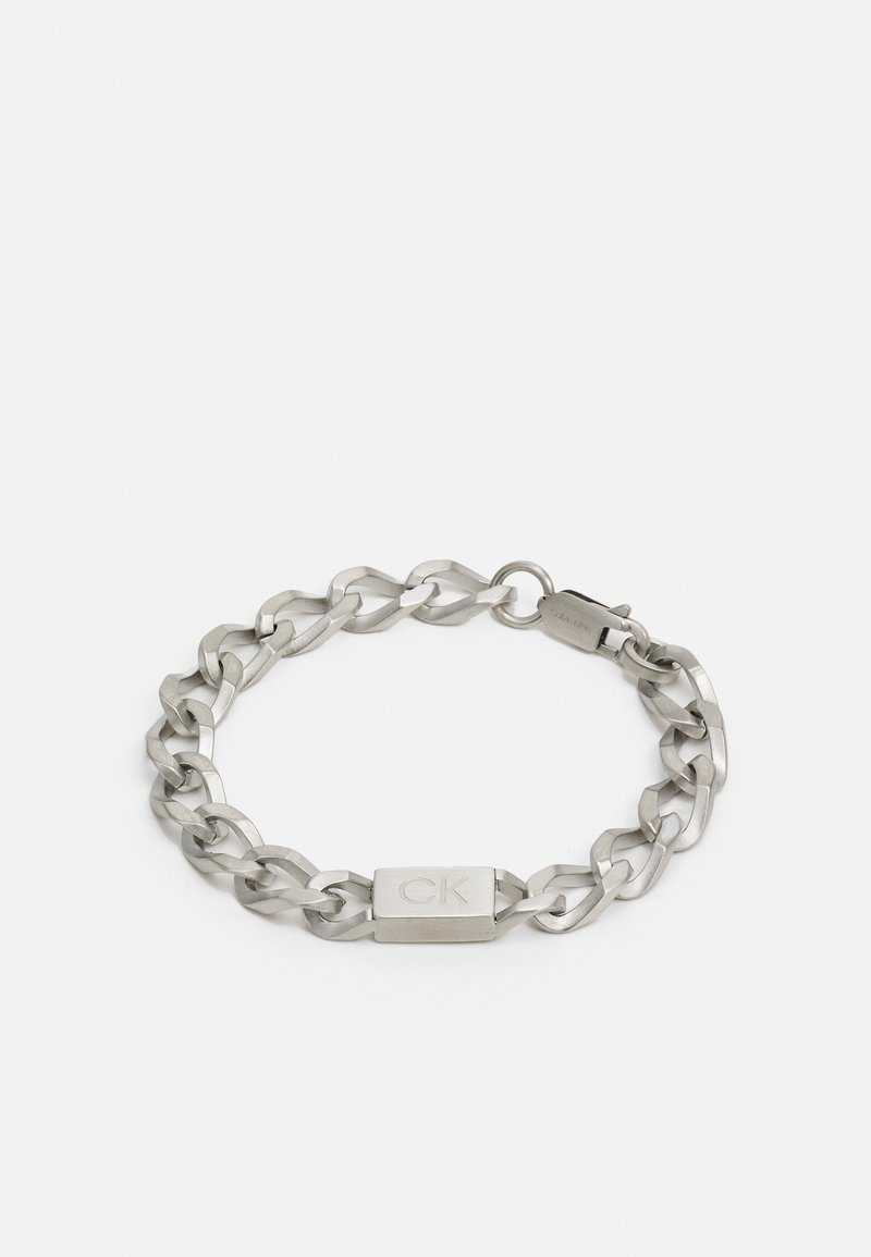 Silver metal chain bracelet featuring interlocking links and a rectangular clasp with an engraved "CK" logo. Smooth texture throughout.