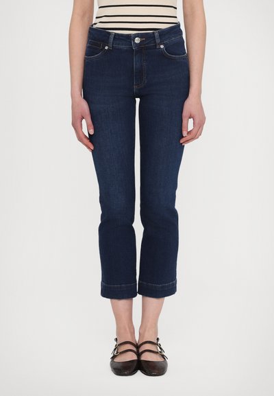 Jeans dżinsowe w ciemnoniebieskim kolorze, ścięte, z prostym krojem nogawek i podwiniętymi mankietami. Posiadają kieszenie z przodu oraz zapięcie na guzik z kontrastowym szwem.