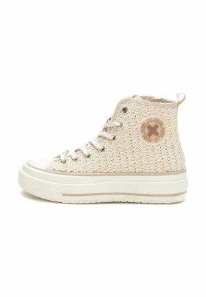 Zapatillas altas color beige hechas de tela tejida. Cuentan con cordones, un logo circular en el lateral y una suela de goma blanca gruesa con una franja beige.