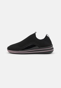 Černé pletené slip-on boty s texturovaným povrchem, s hladkým černým akcentem a růžovými pruhy na podrážce. Lehký design.