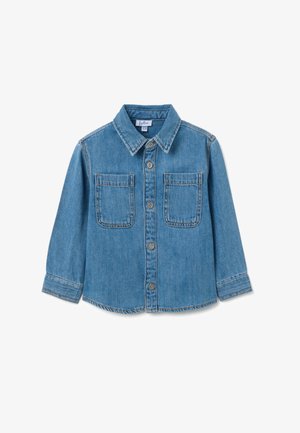 Camisa de denim en azul claro, con cuello puntiagudo, mangas largas y dos bolsillos frontales con cierres a botón. Detalles de costura distintivos.