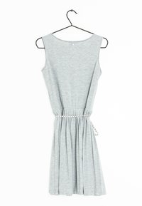 Robe grise sans manches en tissu doux, mettant en avant une taille froncée et une jupe plissée, accentuée par une ceinture tressée. Accrochée à un crochet noir.