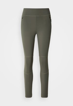 Leggings de sport vert olive à texture lisse, taille haute et poches latérales. Présentent des coutures aux genoux pour plus de structure.