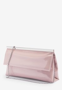 Różowa lakierowana kopertówka z srebrnym łańcuszkiem i metalowym zapięciem. Charakteryzuje się minimalistycznym designem oraz gładką, błyszczącą teksturą.