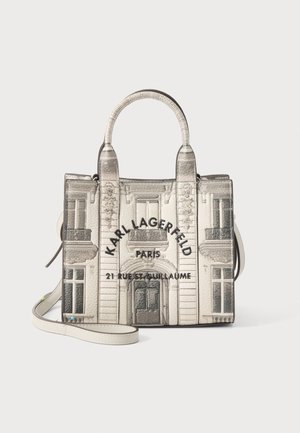 Sac carré avec poignées supérieures et bandoulière, présentant une impression d'un bâtiment parisien et le texte « Karl Lagerfeld Paris 21 Rue St Guillaume ».