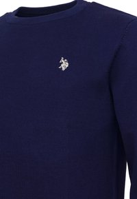 Suéter de punto azul marino con cuello redondo y pequeño logo bordado de jugador de polo blanco en el lado izquierdo del pecho.