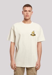 Cream cotton t-shirt with a relaxed fit, featuring a colorful cartoon print of a bird with a hat on the left chest area.