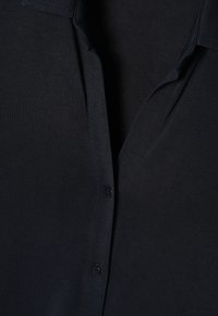 Donker marineblauwe button-up shirt met een gestructureerde stof, omklapbare kraag en vijf zwarte knopen langs de voorplacket.