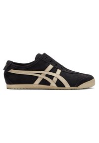 Baskets noires à enfiler avec des rayures beige, des œillets noirs et une semelle beige, vues de profil sur fond blanc.