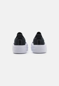 Svarte lerrets sneakers med en tykk hvit gummisåle, med en merket hæl-flik og kontrasterende sømmer. Minimalistisk design.