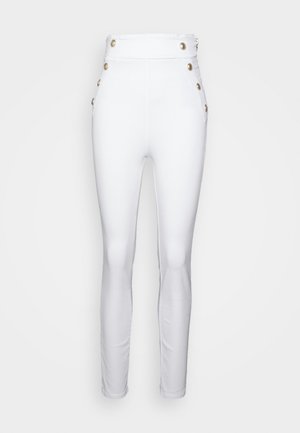 Pantalones blancos de cintura alta con una textura suave, que presentan botones decorativos dorados en los laterales y un ajuste slim y entallado.