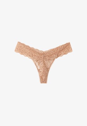 Tanga de encaje desnudo con patrones florales, bordes festoneados y un delicado remate. El diseño resalta una apariencia ligera y transparente.
