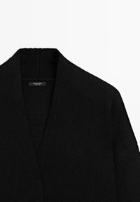 Černý pletený kardigan s výstřihem do V a širokými rukávy. Vyrobený z texturované látky, s etiketou nesoucí nápis "Massimo Dutti."