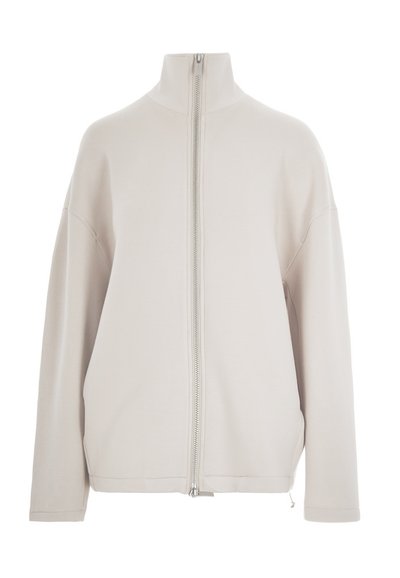 Lys beige zip-up jakke med høy krage, droppede skuldre og lange ermer. Glatt stoff, minimalistisk design med en sølvglidelås.