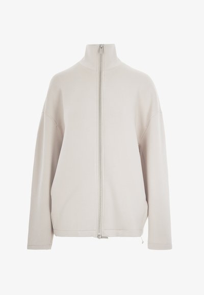 Giacca zip-up beige chiaro con colletto alto, spalle scese e maniche lunghe. Tessuto liscio, design minimalista, con zip argentata.