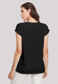 Zwarte T-shirt met korte mouwen, opgerolde mouwen, een relaxed fit en een zachte stof. De achterkant toont een ronde halslijn en een licht gebogen zoom.