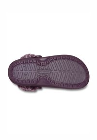 Lila Crocs-Schuhe mit einer strukturierten Gummisohle mit geriffelten Mustern und einem flauschigen Riemen in einer ergänzenden Farbe.