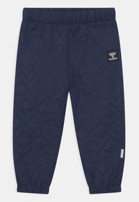 Navyfärgade vadderade byxor med geometriskt mönster, elastisk midja och fotmanchetter. Har en svart Hummel-logotyp på vänster sida.