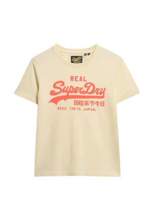 T-shirt en coton beige clair à manches courtes, présentant un logo "SuperDry" rouge bien en vue et du texte japonais sur le devant. Encolure ronde.