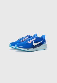 Blå sportsko lavet af mesh og syntetiske materialer. Har et hvidt Nike-slogo, teksturerede snørebånd og en polstret sål.