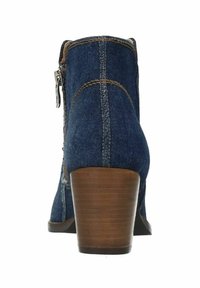Jeansenkelschoen met een taps toelopende bruine hak, ritsdetail aan de zijkant en contrasterende stiksels. Versterkte achterkant en textielstof.