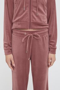 Tuta in velluto rosa polveroso composto da giacca con zip e cordino, e pantaloni abbinati con vita regolabile e tasche laterali.