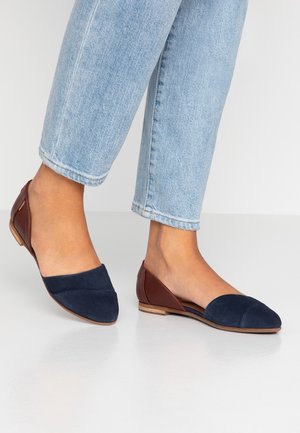 Ballerines en daim bleu marine avec des accents en cuir marron, bout pointu et talon en bois bas ; présente un design en blocs de couleur.