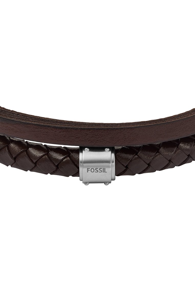 Brauner Lederarmband mit geflochtenem Design und einem silbernen Metallverschluss, auf dem der Markenname "FOSSIL" eingraviert ist.