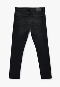 Jeans de mezclilla negra con un diseño ajustado, estilo de cinco bolsillos y detalles traseros minimalistas, con una textura suave y un ligero desvanecimiento.