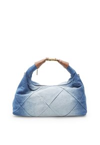 Denim-Handtasche mit Reißverschluss, mit einem gesteppten Design in verschiedenen Blautönen und braunen Lederakzenten am Griff.