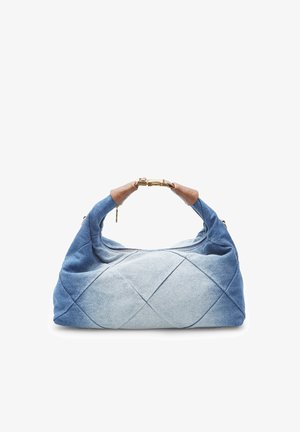 Denimowa torba na ramię z zamkiem błyskawicznym, z pikowanym wzorem w różnych odcieniach niebieskiego oraz brązowymi skórzanymi akcentami na uchwycie.