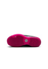 Suela de zapato atlético negra con una base de goma vibrante rosa, con patrones de agarre texturizados y un logotipo circular en el centro.