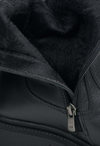 Zwarte leren laars met een gladde buitenkant, voorzien van een ritssluiting met YKK-hardware en een zachte zwarte binnenvoering.