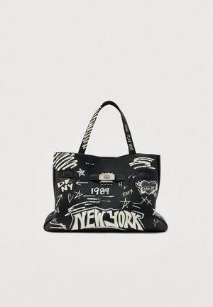 Czarna torba typu tote z białym napisem w stylu graffiti, zawierająca "NEW YORK", gwiazdy oraz srebrną metalową klamrę. Teksturowane wykończenie i solidne paski.